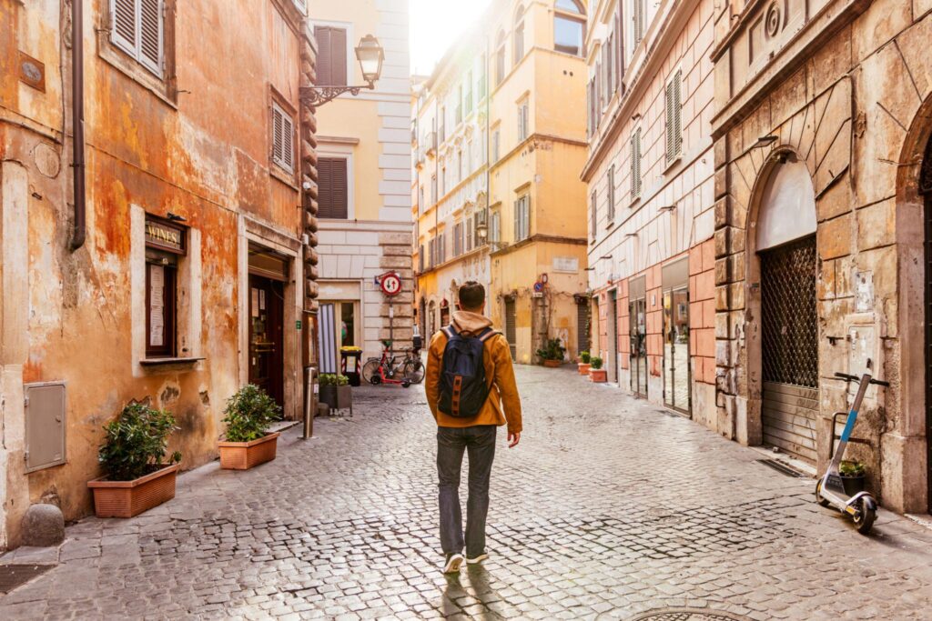 Viajero caminando por una calle tranquila de Roma sin maletas