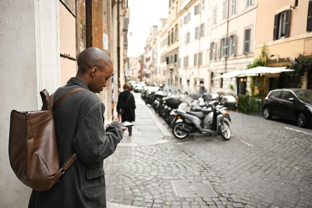 Viajero utilizando su celular en una calle de Roma