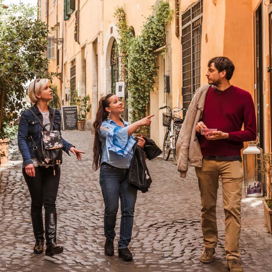 Grupo de turistas realizando un tour guiado por una calle histórica de Roma