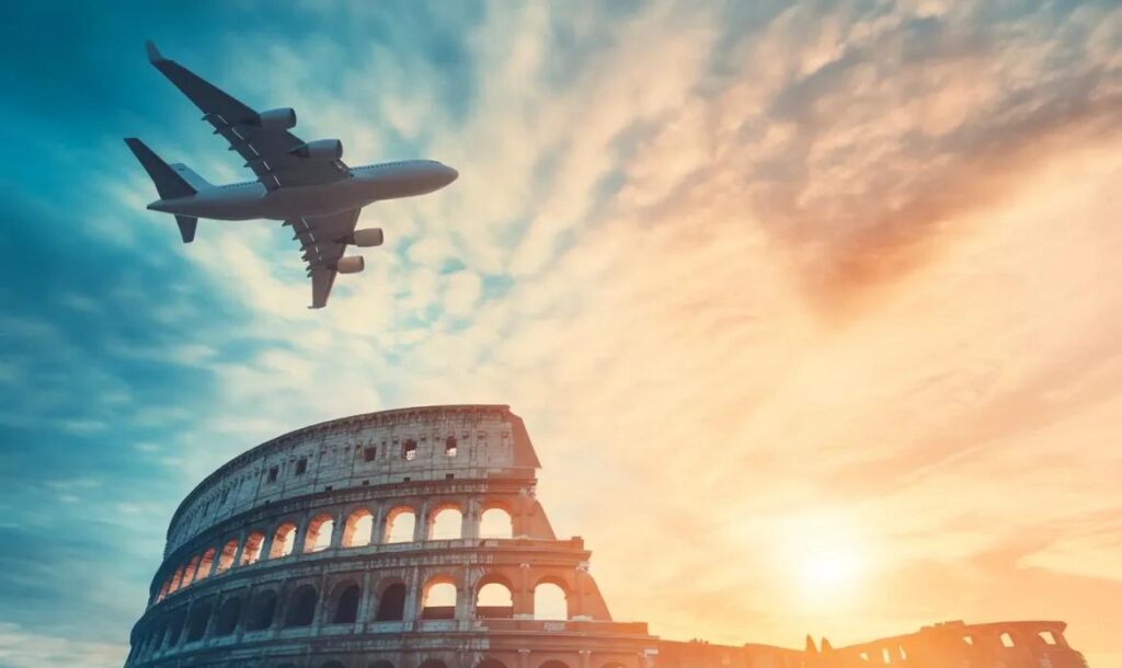 Avión sobrevolando Roma cerca del Coliseo al atardecer