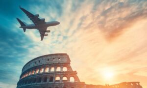 Avión sobrevolando Roma cerca del Coliseo al atardecer