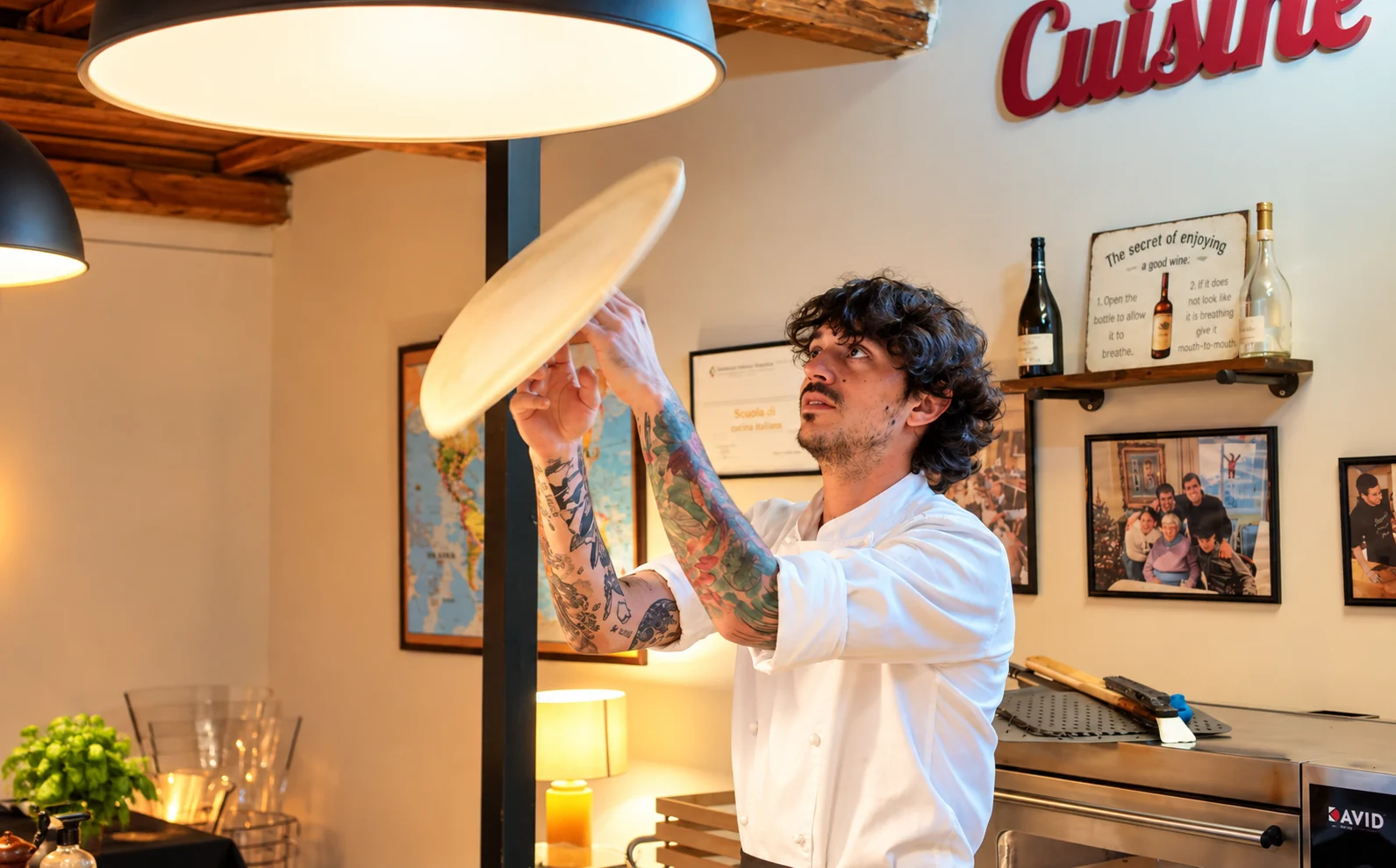 Chef mostrando cómo estirar y hacer girar la masa de pizza durante una clase de cocina en Roma